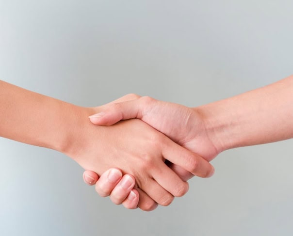 Dos personas dándose la mano, representando una alianza con Alertify